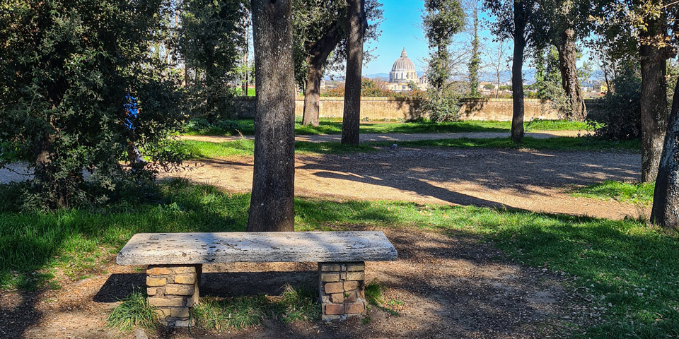 Stone bench with a view of St Peter's Basilica dome from Villa Doria Pamphilj