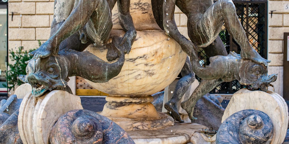 turtle fountain in Rome close up details of sculptures of a young man and a dolphin